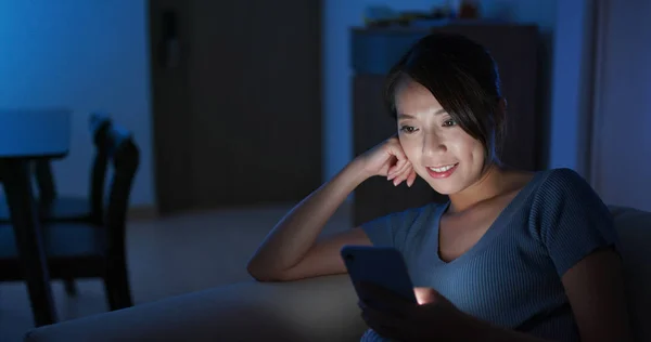 Mujer mira el teléfono móvil por la noche —  Fotos de Stock