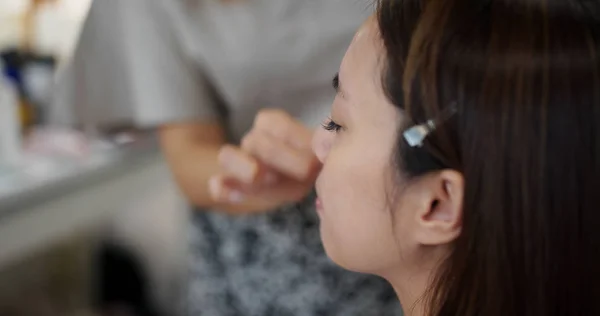 Young woman having make up by artist in the studio — 图库照片