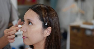 Make up artist do make up on woman model in studio