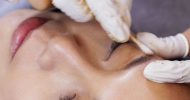 Kalıcı makyajda uzman bir güzellik uzmanı, kaş mikrobıçağı yapıyor.