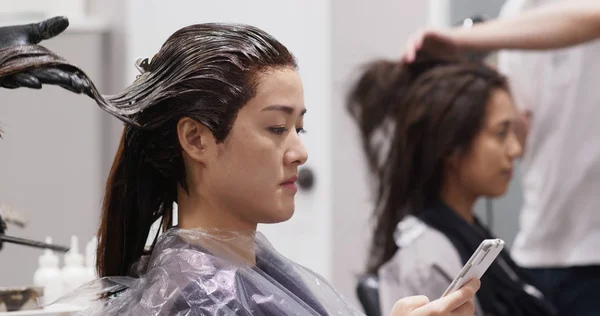 Las niñas van a peluquería juntos, charlando y teniendo tratamiento para el cabello —  Fotos de Stock