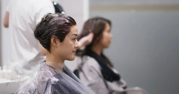 Vänner chattar och väntar på färgen färg på håret i salongen — Stockfoto