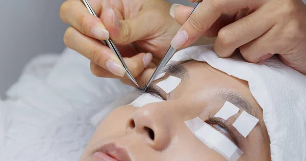 Beautician and young woman in a beauty salon with eye lash exten — Stock Photo, Image