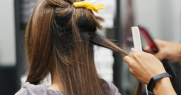 Woman having hair straightening treatment in hair salon — Stockfoto