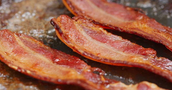 Bak spek in pan in de keuken — Stockfoto