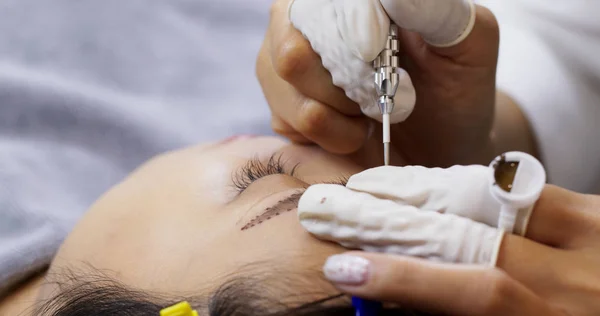 Primi piani della procedura di microblading cosmetologist making — Foto Stock