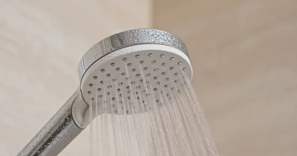 Przepływ wody z głowicy prysznicowej w łazience — Zdjęcie stockowe