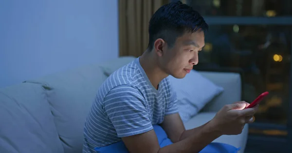 Mężczyzna korzystania z telefonu komórkowego w domu w godzinach wieczornych — Zdjęcie stockowe