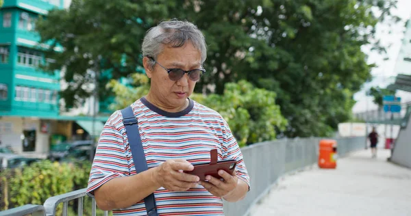 Asiático homem velho uso de telefone celular na cidade — Fotografia de Stock