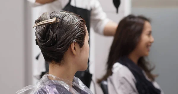 Amici chiacchierano e aspettano la tintura a colori su capelli in salone — Foto Stock