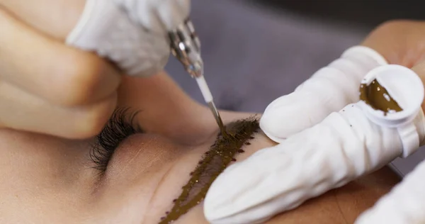 Kosmetolog aplikující trvalé tetování obočí v kráse — Stock fotografie