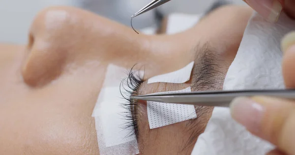 Mujer con extensión de pestañas en salón de belleza — Foto de Stock