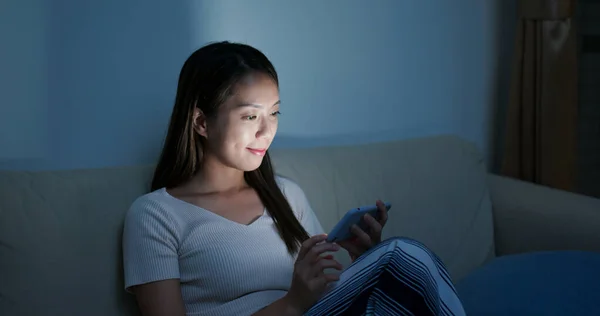 Mujer uso de teléfono inteligente en casa por la noche — Foto de Stock