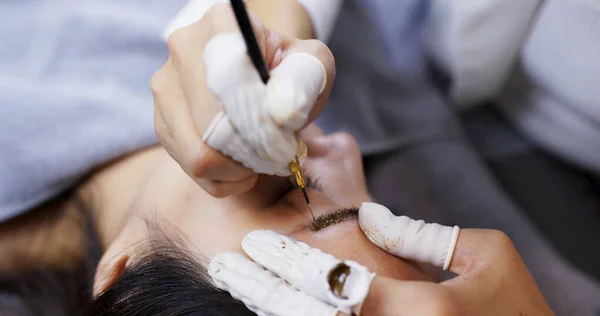 Mulher asiática com sobrancelhas microblading em um salão de beleza — Fotografia de Stock