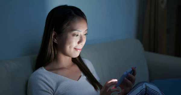 Wieczorem kobieta korzysta ze smartfona w domu — Zdjęcie stockowe