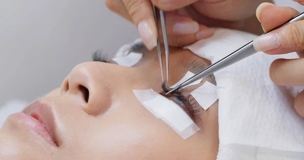 Esthéticienne et jeune femme dans un salon de beauté avec cils exten — Photo