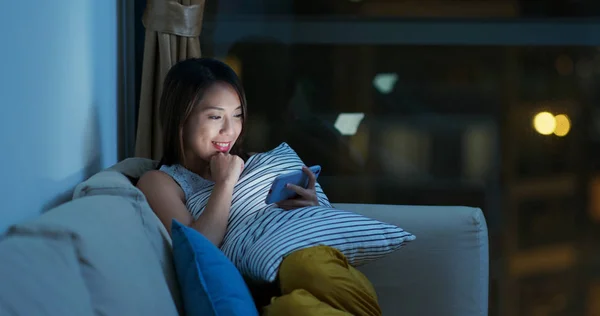 Woman watch video drama on cellphone at night