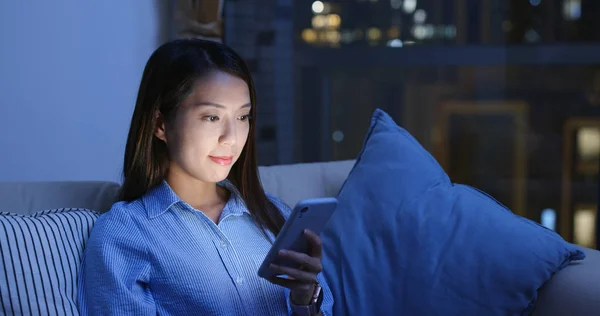 Mujer mira el teléfono móvil en la noche —  Fotos de Stock