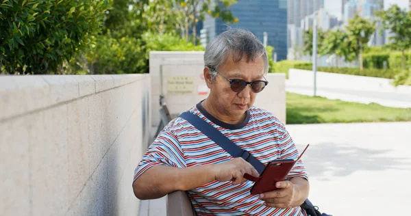 Asiatique vieil homme utilisation de téléphone mobile en ville — Photo