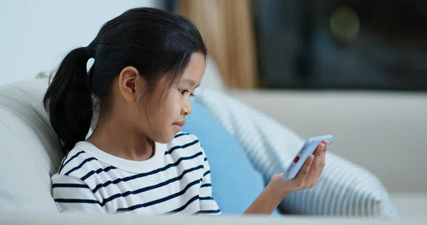 Азиатская девушка смотреть на мобильный телефон дома вечером — стоковое фото