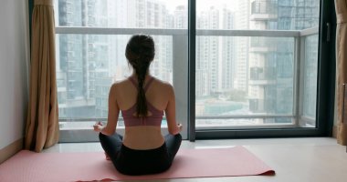 Kadın evde yoga yapıyor.