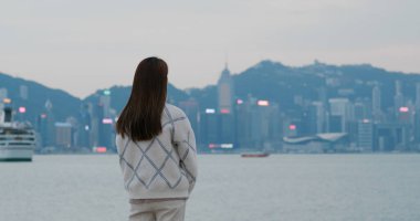 Kadın akşamları şehre bakar.