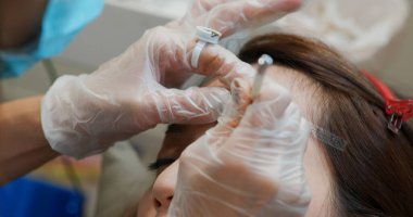 Kadın güzellik salonunda mikro pigmentasyon yaptırıyor.