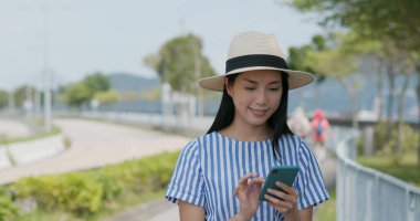 Kadın şehir merkezindeki cep telefonunda arama yapıyor.