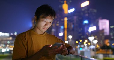 Geceleri akıllı telefon kullanan bir adam.