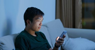 Evde cep telefonu kullanan adam