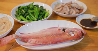 Hong Kong tarzı ev yemekleri, aile yemeği konsepti, haşlanmış balık, kızarmış sebze ve et.