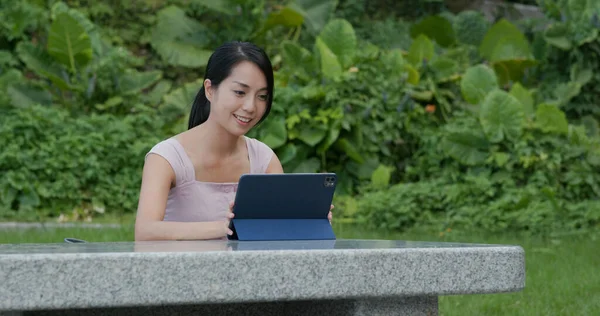 Woman work on tablet computer at park