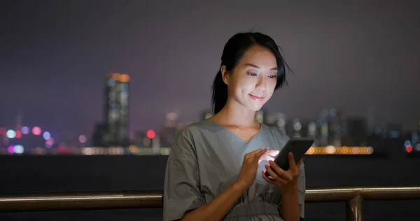 女人在晚上看智能手机 — 图库照片