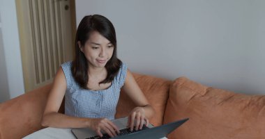 Kadın evde dizüstü bilgisayarda çalışıyor.