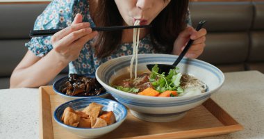 Kadınlar restoranda Tayvan usulü erişte yiyorlar.