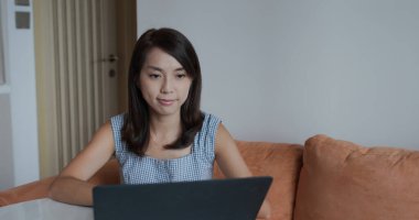 Kadın evde dizüstü bilgisayarda çalışıyor.