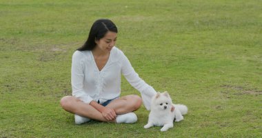 Kadın parkta köpeğiyle oynuyor.