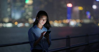 Kadın, gece akıllı telefonu kontrol et.