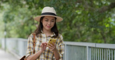 Yürüyüşe giderken cep telefonu kullanan kadın