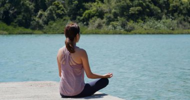 Güzel manzarada yoga yapan bir kadın.