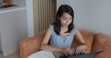 Kadın evde dizüstü bilgisayarda çalışıyor.