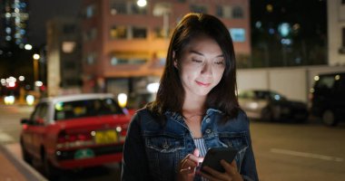 Geceleri Asyalı kadın cep telefonu kullanıyor