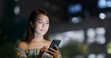 Geceleri kadın cep telefonu kullanıyor.