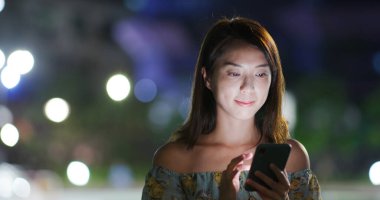 Geceleri kadın akıllı telefon kullanıyor.