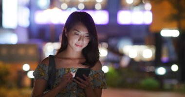 Geceleri kadın cep telefonu kullanıyor.