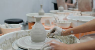 Çömlek çarkında el işi, kilden bir kap şekillendirme.