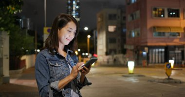 Asyalı kadın açık havada cep telefonu kullanıyor