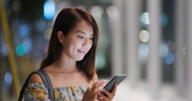 Geceleri kadın akıllı telefon kullanıyor.