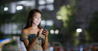 Geceleri kadın cep telefonu kullanıyor.