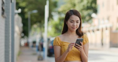 Şehirdeki kadınlar cep telefonlarını kullanırlar.